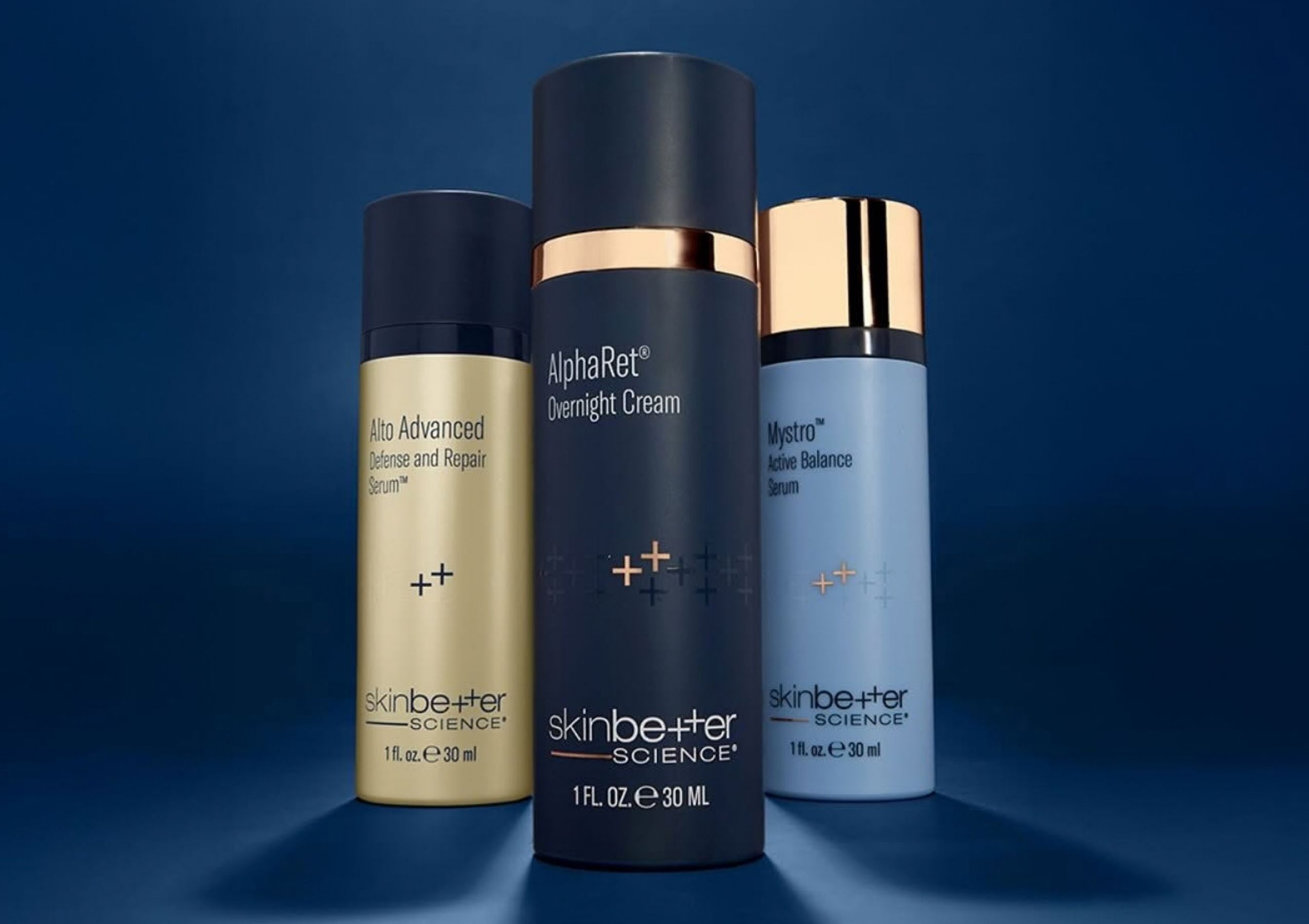 Three SkinCeuticals serum bottles with dropper tops, containing orange, clear, and purple liquids, arranged in a row on a gray background.